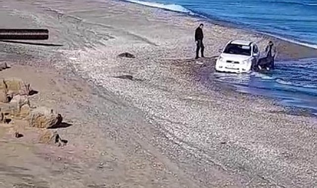 Kumsalda otomobilyle gezerken, denizde mahsur kaldı