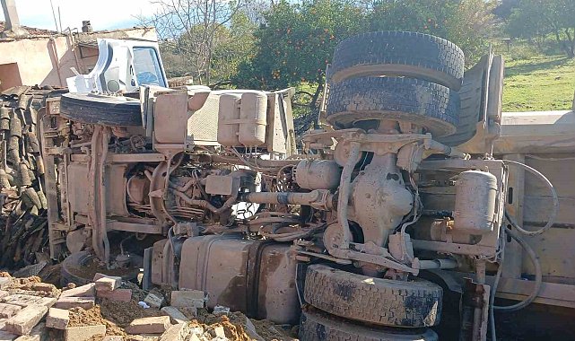 Otobüse çarpan kum yüklü kamyon, bir evin bahçesine devrildi