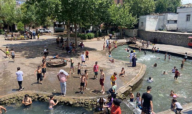 Diyarbakır'da çocuklar ailelerinin nezaretinde süs havuzunda serinliyor