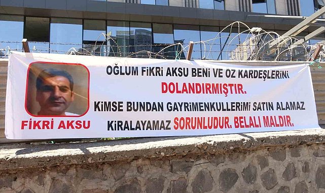 Diyarbakır'da oğlu tarafından dolandırıldığını iddia eden baba, olayı pankartla duyurdu